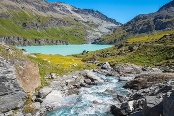 picturesque landscape with rapid mountain stream and glacial lake in the Swiss Alps