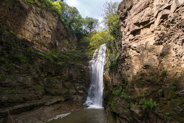 Fototapeta na wymiar Canyon with a waterfall in the Abanotubani district in Tbilisi