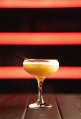 Fresh yellow cocktail on a neon background. Alcoholic cocktail. Fruit Non-alcoholic cocktail.