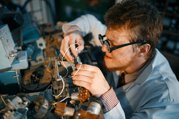 Scientist prototyping electrical device in lab