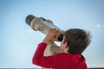 Fototapeta na wymiar the boy watches the tourist telescope on