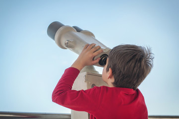 the boy watches the tourist telescope on