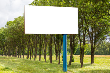 Mock-up of white blank advertising board standing in field along road