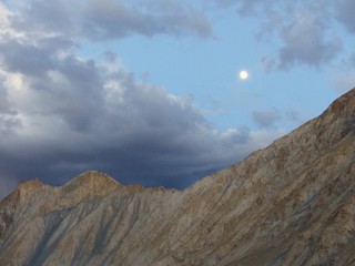 Cima di una montagna al tramonto con la luna nel Ladakh in India.