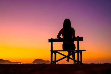 Lifestyle A girl in a beautiful sunset sitting on a chair. Copyspace