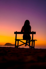 Fototapeta na wymiar Lifestyle, a girl a chair in a beautiful purple sunset, vertical photography