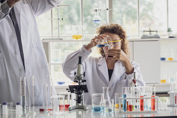 Team of Medical Research Scientist Conducts Experiments in Laboratory with Microscope, Test Tubes, Micropipette and other equipment.