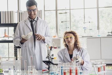 Team of Medical Research Scientist Conducts Experiments in Laboratory with Microscope, Test Tubes, Micropipette and other equipment.