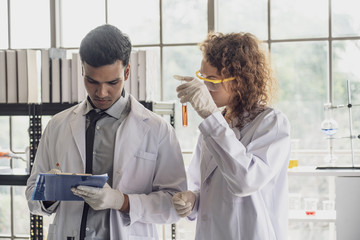 Team of Medical Research Scientist Conducts Experiments in Laboratory with Microscope, Test Tubes, Micropipette and other equipment.