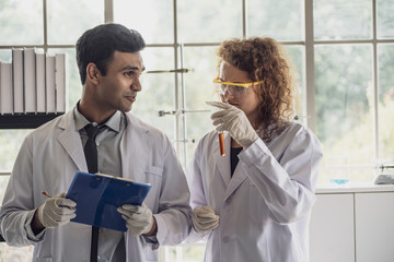 Team of Medical Research Scientist Conducts Experiments in Laboratory with Microscope, Test Tubes, Micropipette and other equipment.