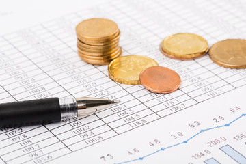 Finance Concept. Financial reports, euro coins, US coin  on business chart.