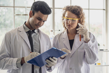 Team of Medical Research Scientist Conducts Experiments in Laboratory with Microscope, Test Tubes, Micropipette and other equipment.