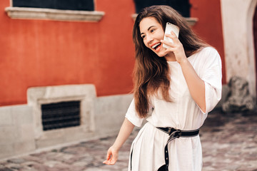 Beautiful woman traveler  using phone walking on the old town street.