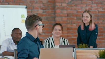 Young Caucasian IT Worker Man with Laptop is Discussing Ideas with his Diverse Team in Loft Office. 4K Medium Corporate Shot
