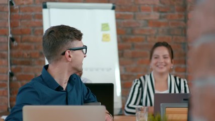 Young Happy IT Worker Man is Discussing Ideas with his Diverse Team in Loft Office. 4K Medium Close up Corporate Shot