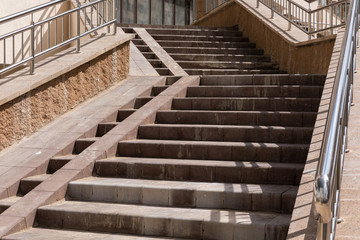 High concrete paved beige stairs leading to apartment entrance.