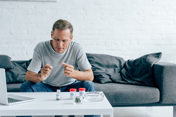 handsome man in t-shirt rolling blunt with medical cannabis
