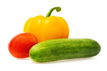 Closeup image of vegetables festive three colors group. Red tomato, green cucumber and yellow pepper isolated at white background.