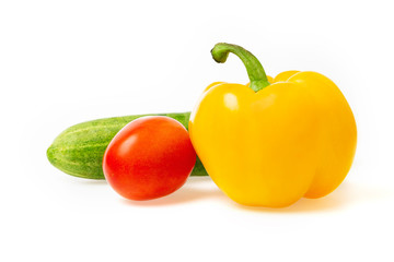 Closeup image of vegetables festive three colors group. Red tomato, green cucumber and yellow pepper isolated at white background.