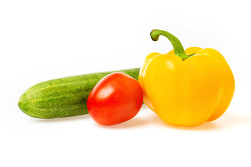 Closeup image of vegetables festive three colors group. Red tomato, green cucumber and yellow pepper isolated at white background.