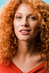 Fototapeta premium portrait of beautiful smiling redhead woman isolated on blue