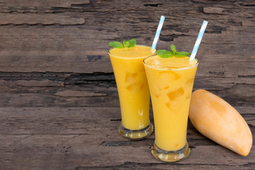 Mango smoothies juice orange fruit juice milkshake blend beverage healthy high protein the taste yummy in glass episode drink morning on wood background.