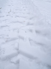A closeup view of ATV or all terrain vehicle tracks in fresh white snow in Wisconsin.