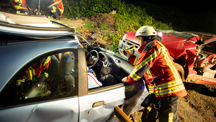 Feuerwehr Nachtübung, befreien eingeklemmter Person im Auto, mit hydraulischem Rettungssatz