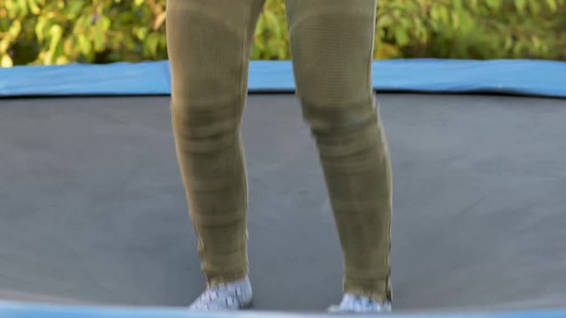 F&uuml;&szlig;e mit Socken h&uuml;pfen auf einem Trampolin im Garten