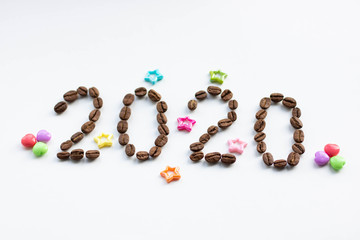 Top view of coffee beans and word 2020 for Happy New Year Concept. on white background