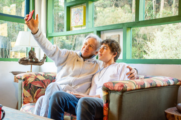 Father and teenage son with mobile phone fun social network