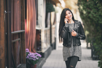 Fototapeta premium Girl walks the streets of the city, using the phone.