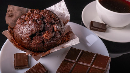 Chocolate muffin, Chocolate and cup of black coffee on the table.
