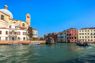 View of Canal Grande. Various boats float by a fine architectural complex of embankments.