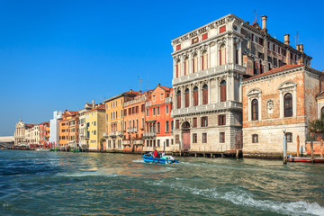 View of Canal Grande. Various boats float by a fine architectural complex of embankments.