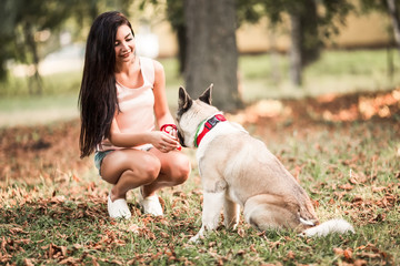 Portrait of pretty woman with her don in the park.