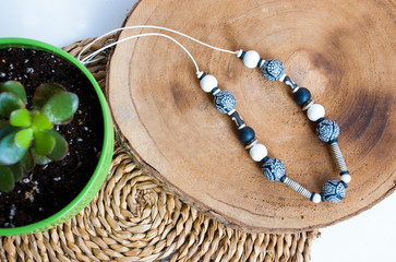 Top view jewelry background with black and white beaded necklace in boho style.