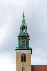 Fototapeta na wymiar Bell Tower of St Mary's Church (Marienkirche) against cloudy sky. The church was originally a Roman Catholic church, but has been a Lutheran Protestant church since the Protestant Reformation.