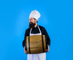Homemade wine. Wooden barrel of beer. Bearded cook with wooden barrel of beer. Equipment for preparate of beer. Brewery for maturing alcohol. Celebration oktoberfest festival. Beer in Germany. Barman.