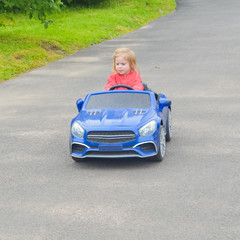 the girl driving a car electric car on the road child