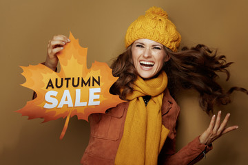 woman showing autumn sale banner isolated on brown background