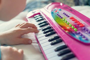 child plays a toy synthesizer. children's piano. development of musical abilities in children