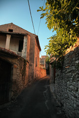 Narrow street with stone pavement of old town of Barjac. European old town at sunset, south France