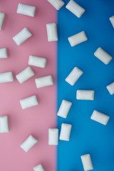 Fototapeta na wymiar Texture of white chewing gum on a pink and blue background. Close up. Flat lay. Concept of men or women