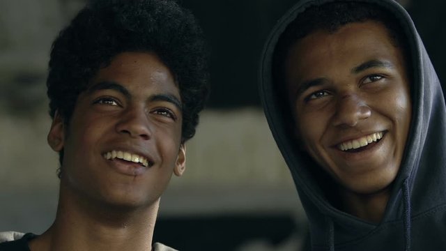 Young African-American friends hooligans watching fight and smiling, bad boys