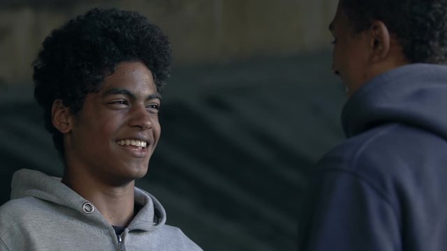 African-American male friends smiling and bumping fists, greeting gesture
