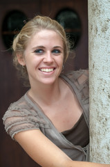 Fototapeta premium Young blonde girl photographed in the cloister of an old building