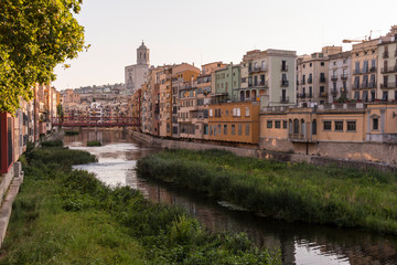 Colorful yellow and orange houses reflected in water river Onyar, in Girona, Catalonia, Spain.