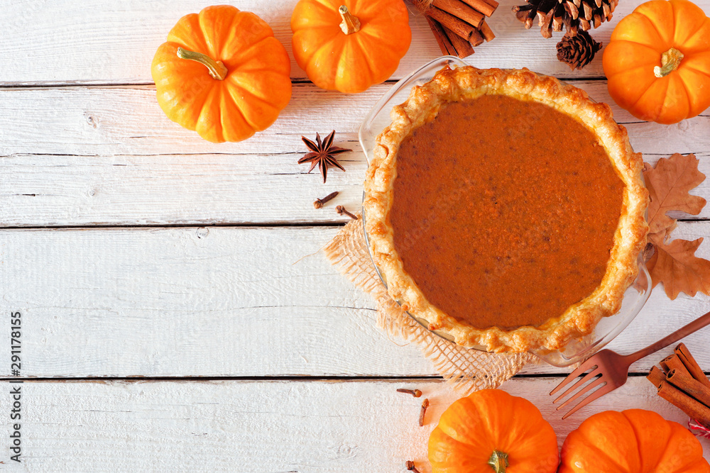 Poster homemade autumn pumpkin pie corner border. top view table scene over a white wood background with co