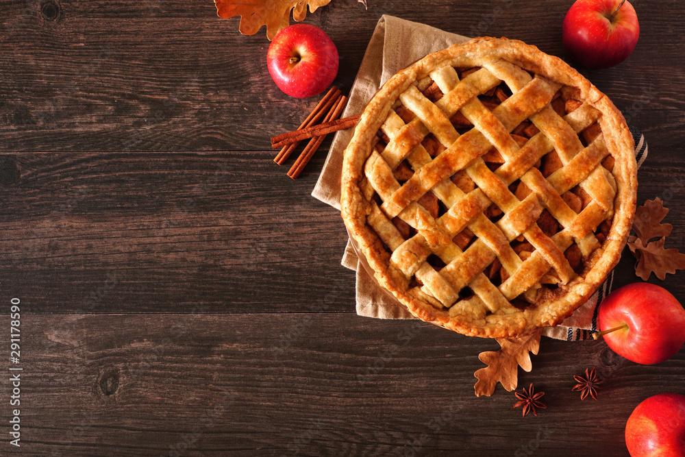Poster Homemade autumn apple pie corner border. Above view table scene over a dark wood background with copy space.
